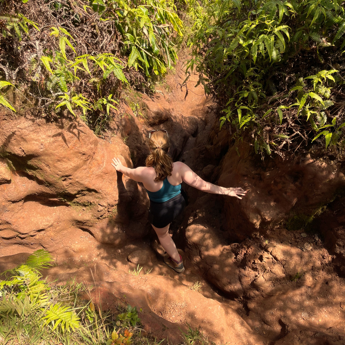 Kait hiking deep in a rock crevice on Kauai, Hawaii