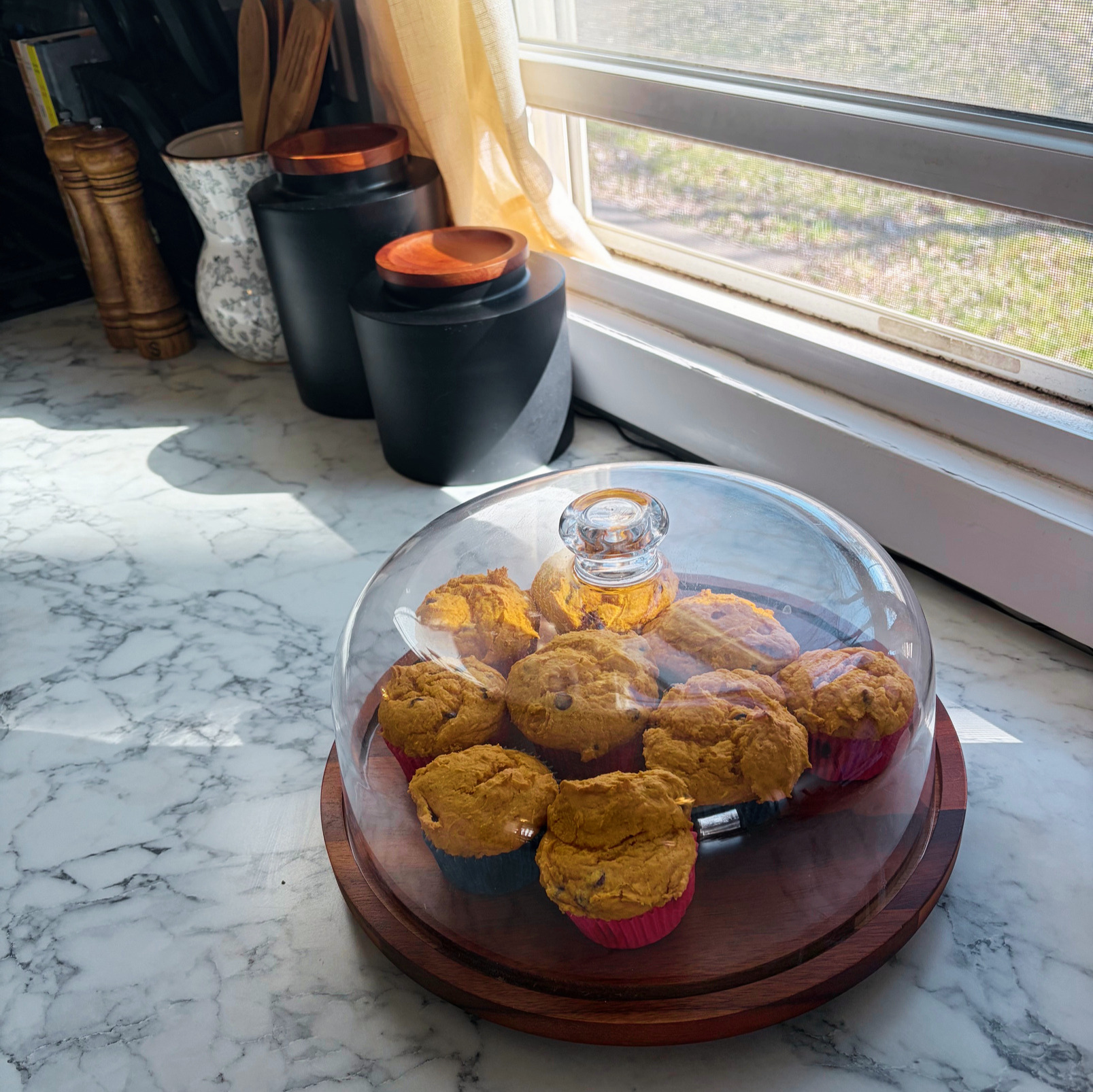 Pumpkin muffins displayed in a cake stand on the counter