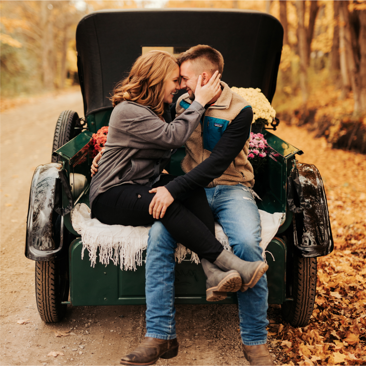 Kait and husband sitting in the back of a Model T pickup truck