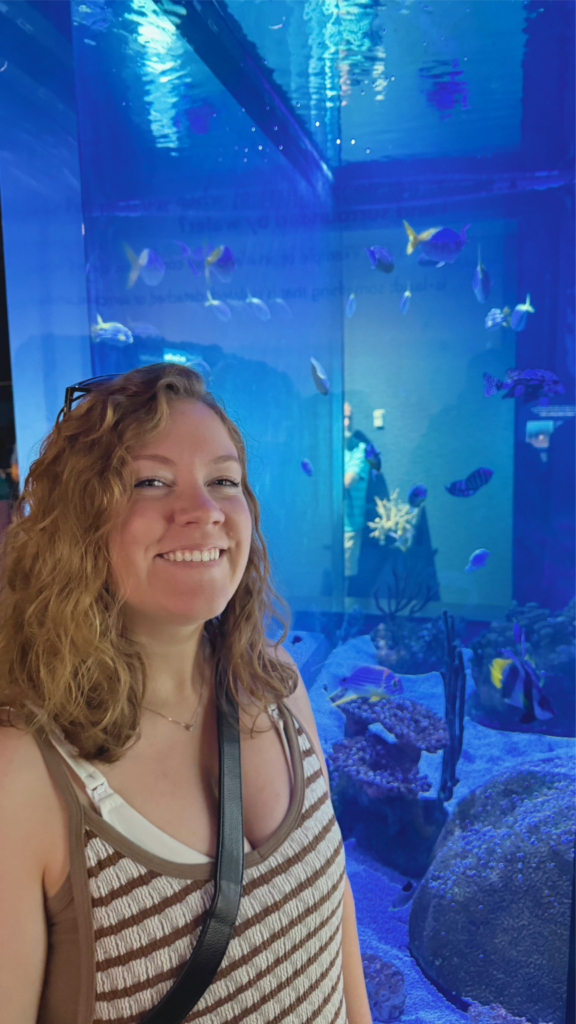 Kait smiling in front of the aquarium
