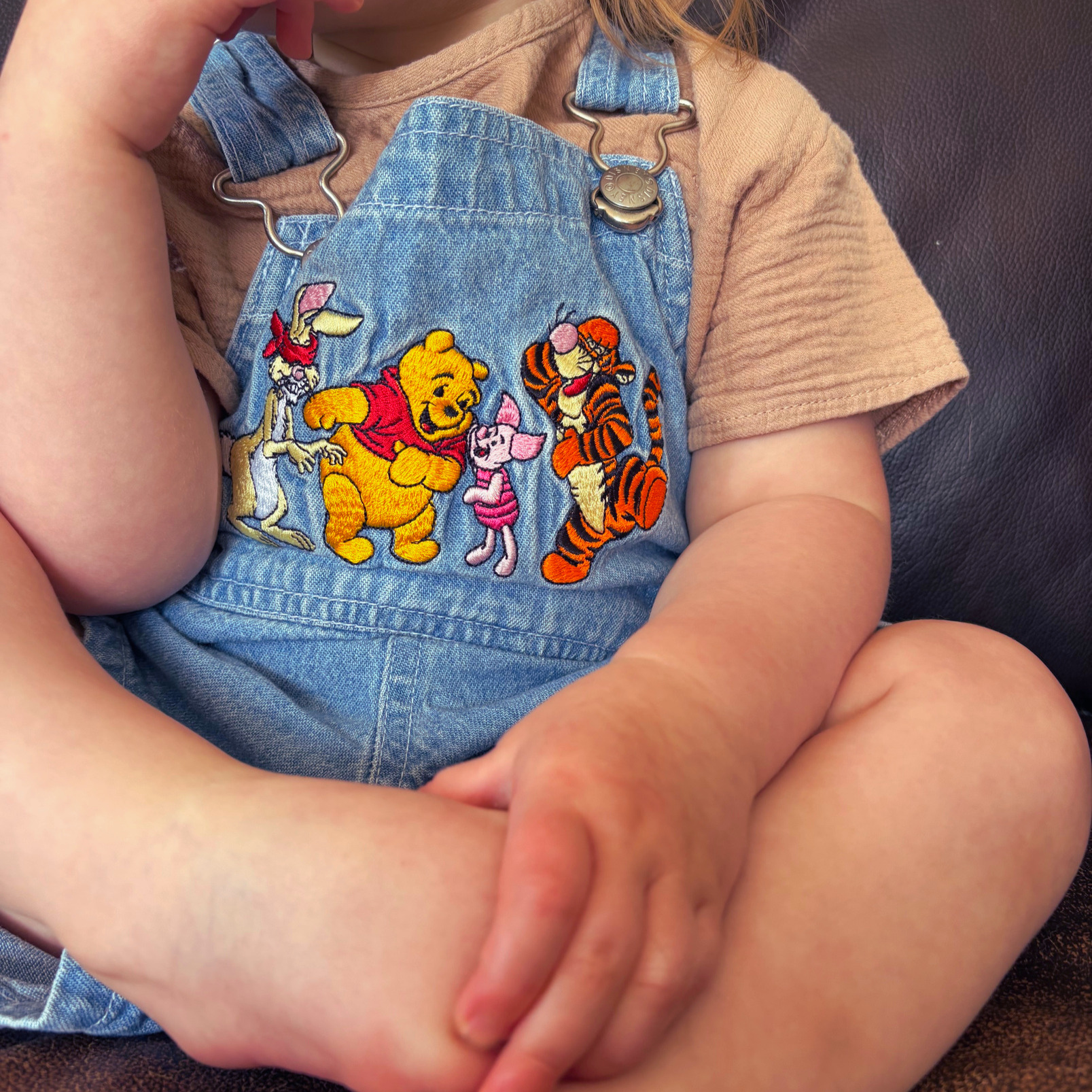 Winnie the Pooh denim overalls on a toddler