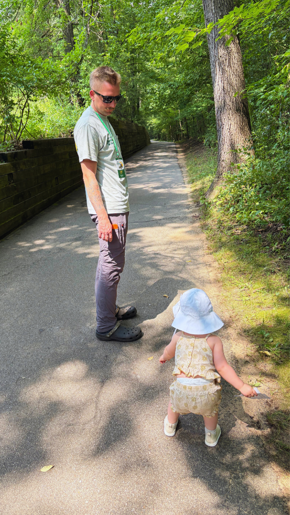 Kait's husband and daughter walking on a paved trail in the Hidden Lake Gardens