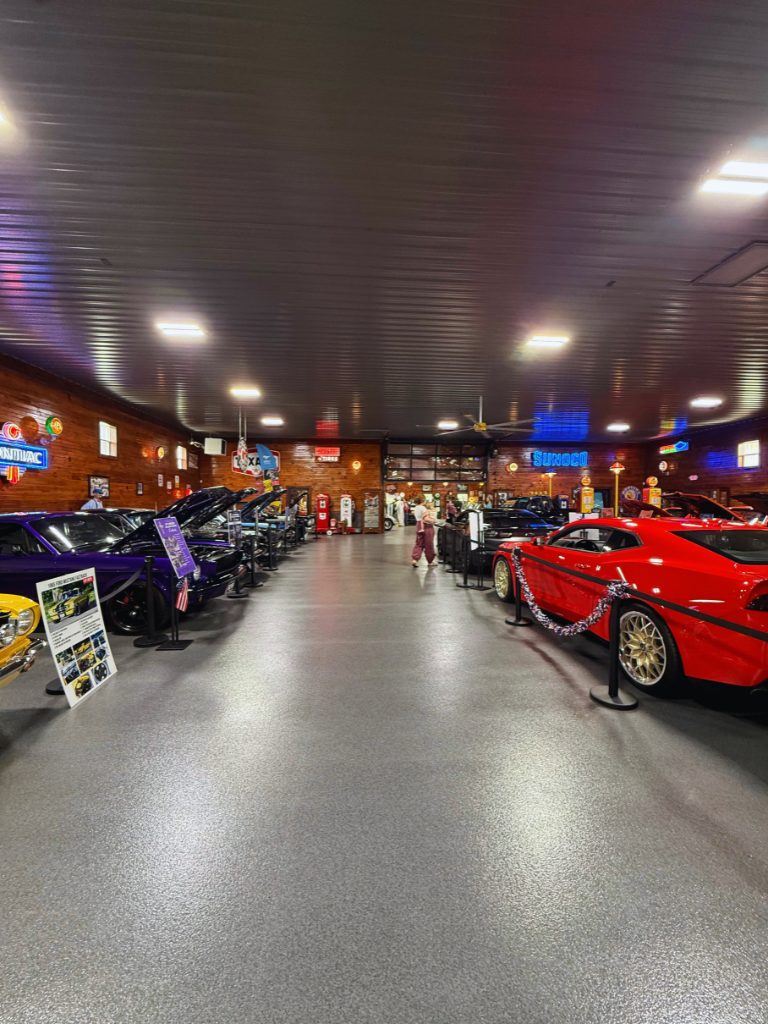 Kait and her daughter walking through a car display at the Millbury Auto Museum