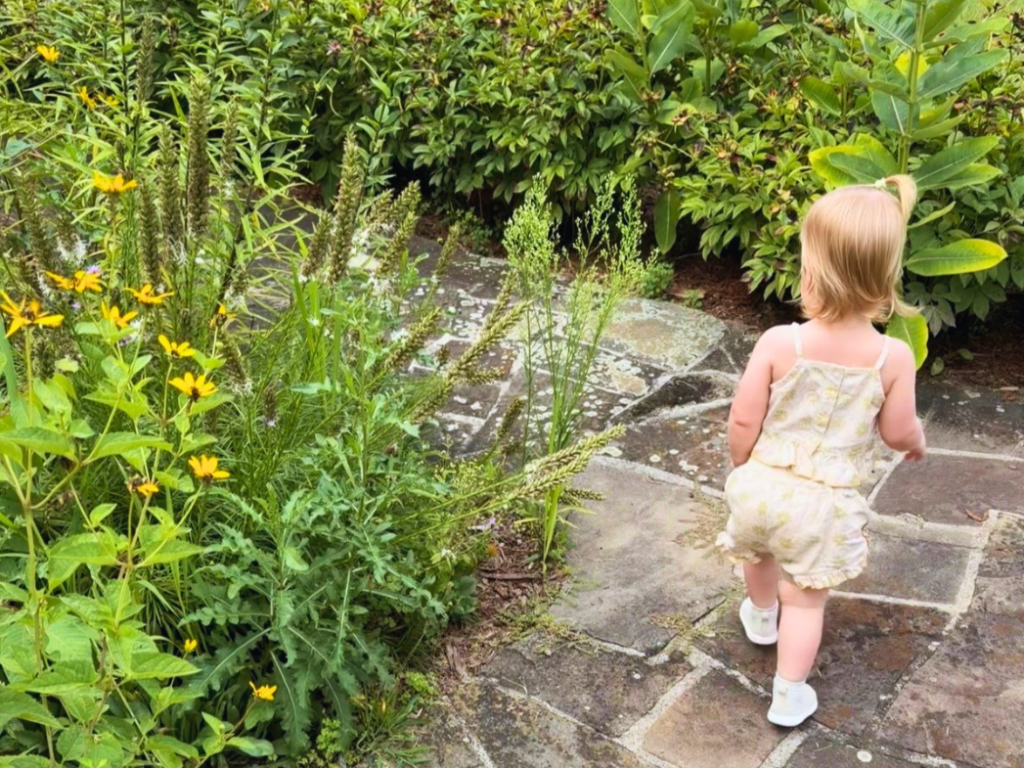 Kait's daughter walking around the landscaping at the house on the Macon Mill property